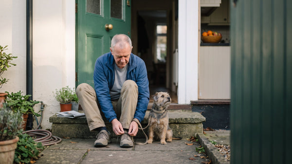 A man and his dog getting ready for a morning walk.